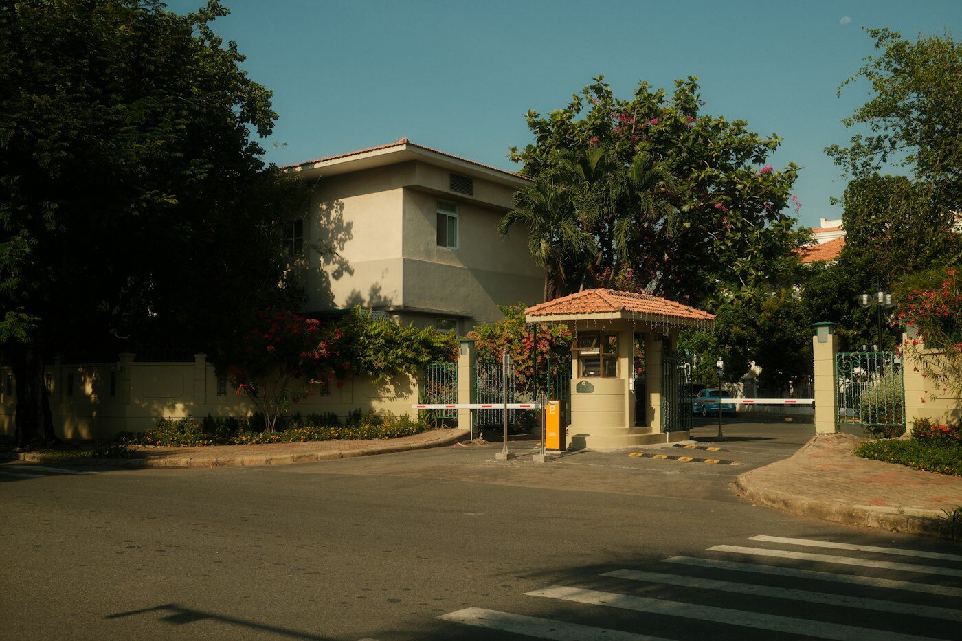Entrada de condomínio com guarita de portaria e cancela